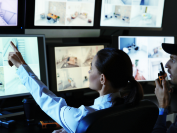 commercial alarm response with 2 guards looking at cctv and surveillance footage on screens
