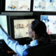 commercial alarm response with 2 guards looking at cctv and surveillance footage on screens
