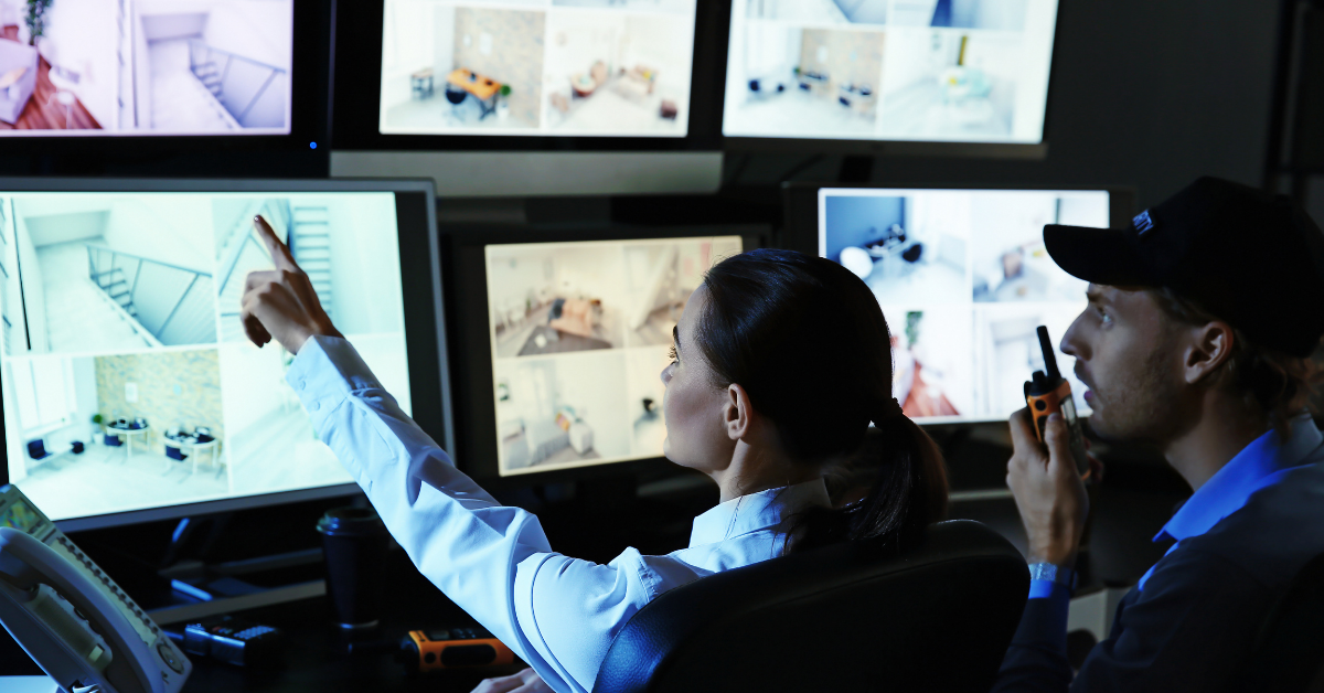 commercial alarm response with 2 guards looking at cctv and surveillance footage on screens